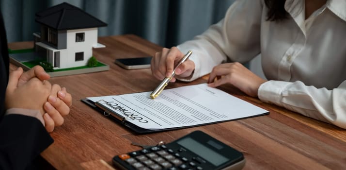 Reviewing house loan contract with agent. Analyzing financial documents and tax rates with calculator for ownership of property. Key signature for new home purchase and financing. Enthusiastic