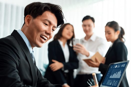 Portrait of focus young successful confident male manager, executive wearing business wear in harmony office arm crossed with blurred meeting background of colleagues, office worker.