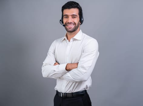 Male call center operator wearing headset and formal suit standing confidently on isolated background portrait. Professional smile and service minded for customer service and support. fervent