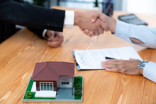 Successful house loan agreement sealed with a handshake. Buyers and agents celebrate the home ownership of property with a sense of accomplishment and satisfaction. Fervent