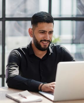 Bearded young businessman working on modern office.