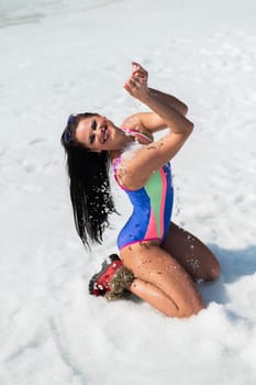 Caucasian woman in a swimsuit sunbathes on the snow in winter