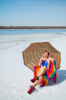 Caucasian woman in a swimsuit sunbathes on the snow in winter