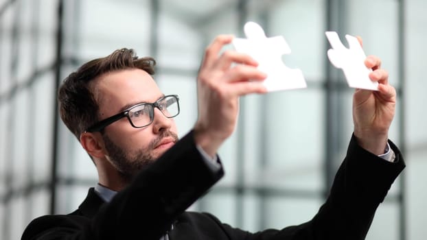 businessman show white jigsaw in hand, business strategy concept