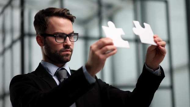 businessman show white jigsaw in hand, business strategy concept
