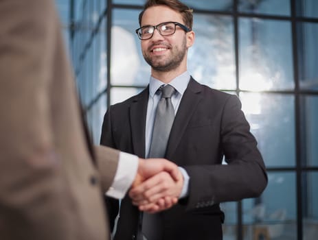 employees greeting each other with a handshake in the office corridor .