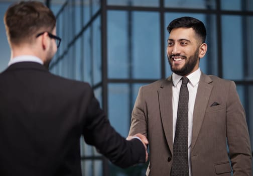 colleagues shaking hands in the office lobby