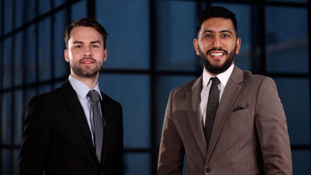 Two happy men standing with arms folded