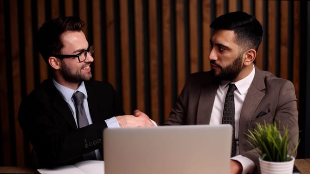 handshake business people sitting at the table