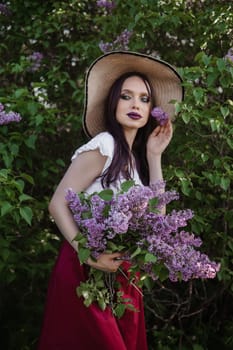 A fashionable girl with dark hair, a spring portrait in lilac tones in summer. Bright professional makeup