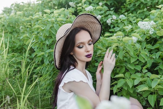 A fashionable girl with dark hair, a spring portrait in lilac tones in summer. Bright professional makeup