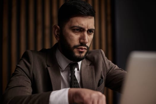 Businessman using a laptop while working late in his office