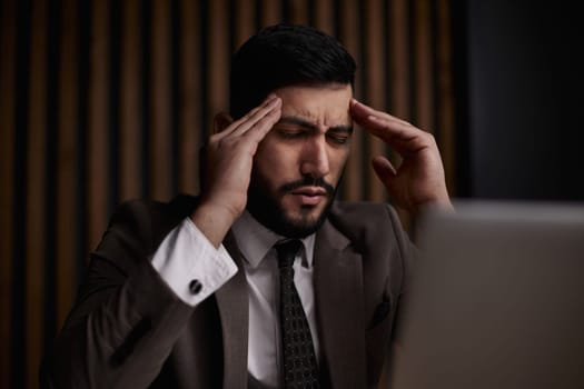 Businessman using a laptop while working late in his office