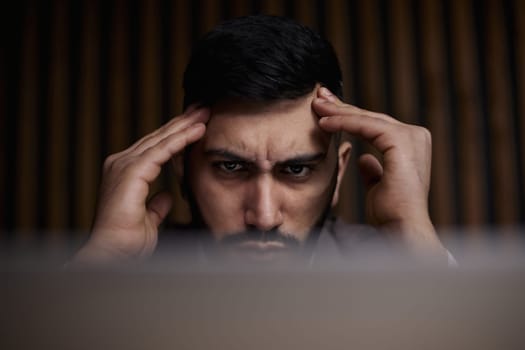 Businessman using a laptop while working late in his office