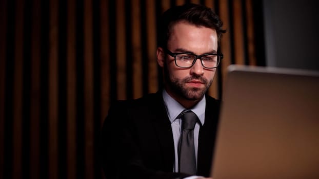 Shot of a young businessman using a computer at his desk in a modern office.