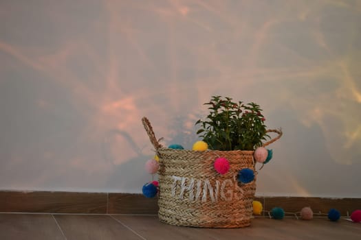 A vase of flowers decorated with decor and multi-colored balls. Bag straw.