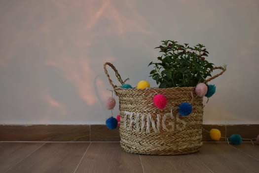 A vase of flowers decorated with decor and multi-colored balls. Bag straw.