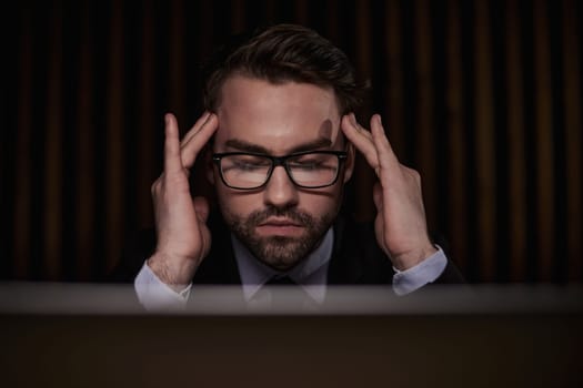 Worried businessman holding his head in his hands