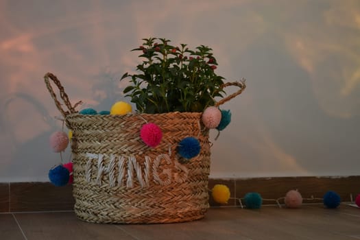 A vase of flowers decorated with decor and multi-colored balls. Bag straw.