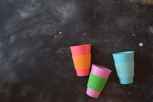 Colorful plastic cups in a black background.
