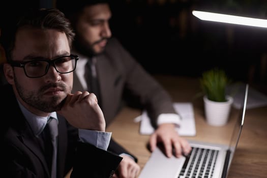 Two middle-aged business workers work at a desk in an office.