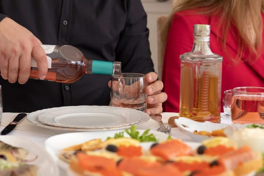 Young man pouring wine from the bottle into a glass . wine at restaurant. High quality photo