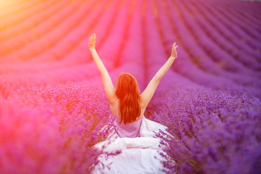 A middle-aged woman sits in a lavender field and enjoys aromatherapy. Aromatherapy concept, lavender oil, photo session in lavender.