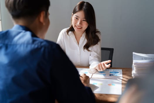 Accountant checking financial statement or counting by calculator income for tax form, Business woman sitting and working with colleague discussing the desk in office. Audit concept.