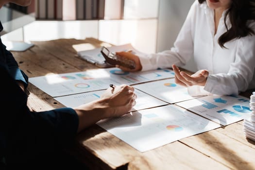 Accountant checking financial statement or counting by calculator income for tax form, Business woman sitting and working with colleague discussing the desk in office. Audit concept.