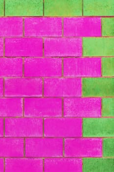 Green and purple pink paint on brick blocks urban color vibrant design wall texture background architecture.