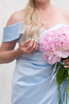 bride in a blue wedding dress with a bouquet of pink peonies, pastel paradise, floral background, complementary color combination. High quality photo