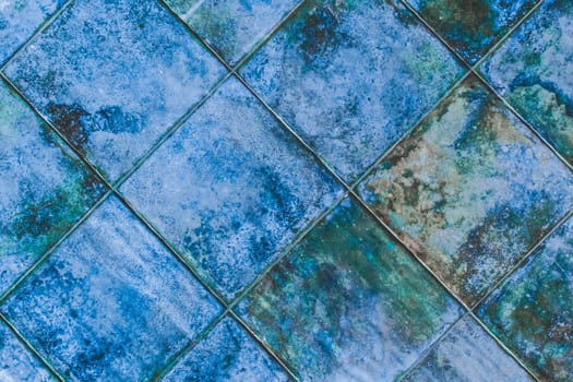 Blue diagonal square ceramic floor tiles with abstract pattern, mosaic texture background.
