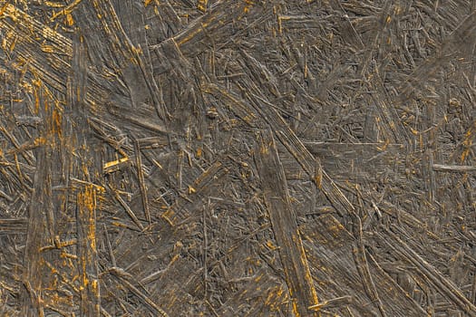 Dark paint on abstract surface of pressed wood chipboard texture particleboard pattern timber background.