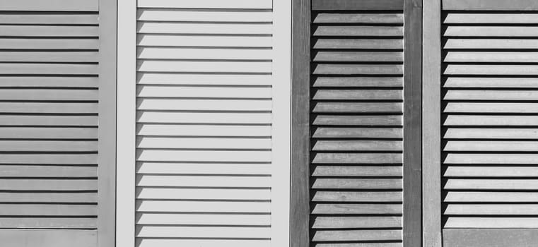 Part of modern interior with grey patterned texture of wooden black and white shutters, casements or blinds background.