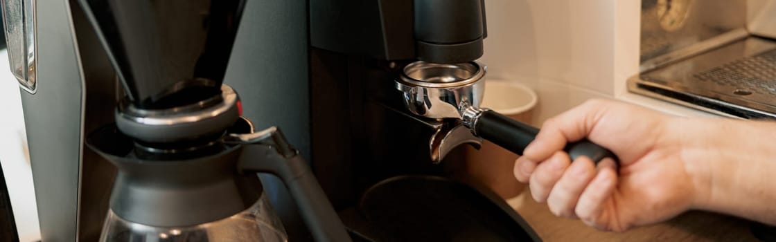 Closeup of hand barista grinding coffee, prepare to brewing espresso shot