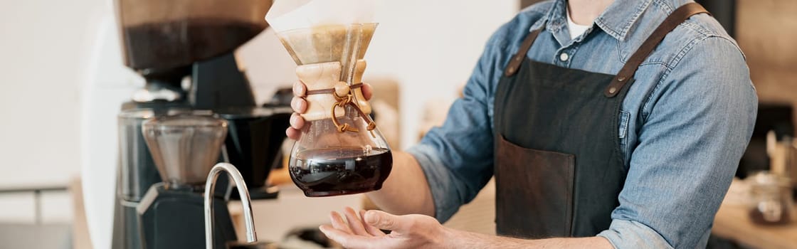 Close up of barista offering filter coffee to customer while standing at counter