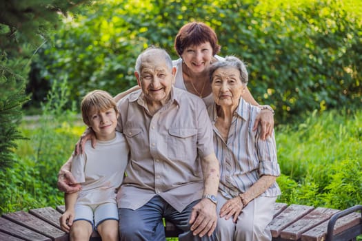 Four generations of family spend time together in the park. Elderly couple. Senior husband and wife holding hands and bonding with true emotions.