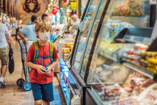 The boy looks at the counter with Turkish sweets. Traditional oriental sweet pastry cookies, nuts, dried fruits, pastilles, marmalade, Turkish desert with sugar, honey and pistachio, in display at a street food market.