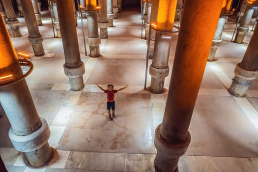 boy tourist enjoying Beautiful cistern in Istanbul. Cistern - underground water reservoir build in 6th century, Istanbul, Turkey, Turkiye.