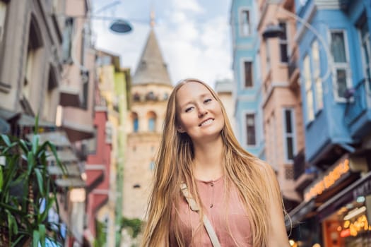 Portrait of beautiful woman tourist with view of Galata tower in Beyoglu, Istanbul, Turkey. Turkiye.