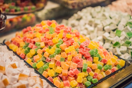 Traditional oriental sweet pastry cookies, nuts, dried fruits, pastilles, marmalade, Turkish desert with sugar, honey and pistachio, in display at a street food market.