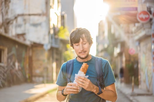 Man eating street food in Istanbul. Balik ekmek - fish in a bread, traditional Turkish fast food. Istanbul, Turkey.