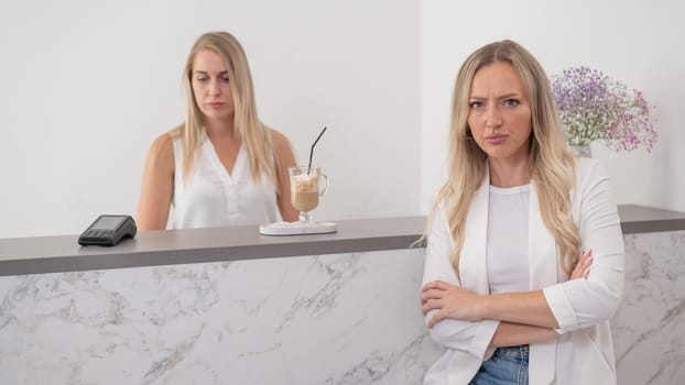 Dissatisfied client stands at the reception of a beauty salon