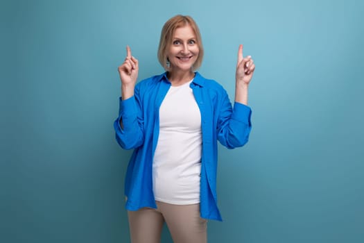 kind cute middle aged woman in casual shirt on blue background.