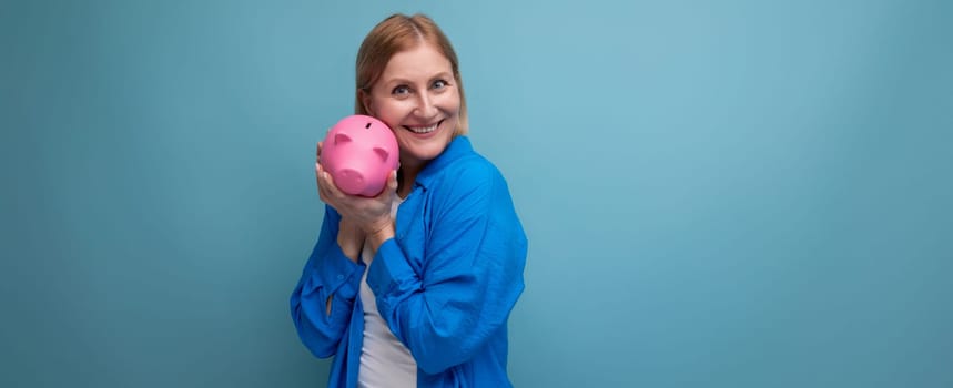 successful adult business woman with accumulated money capital on blue background with copy space.