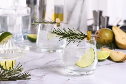 Gin Cocktail with lime, rosemary, ripe pear and tonic. This refreshing, organic drink is full of vibrant flavors and aromatic herbs.