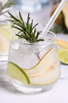 Gin Cocktail with lime, rosemary, ripe pear and tonic. This refreshing, organic drink is full of vibrant flavors and aromatic herbs.