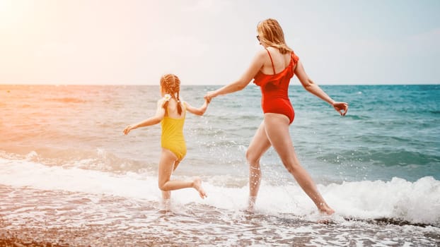 Happy loving family mother and daughter having fun together on the beach. Mum playing with her kid in holiday vacation next to the ocean - Family lifestyle and love concept.