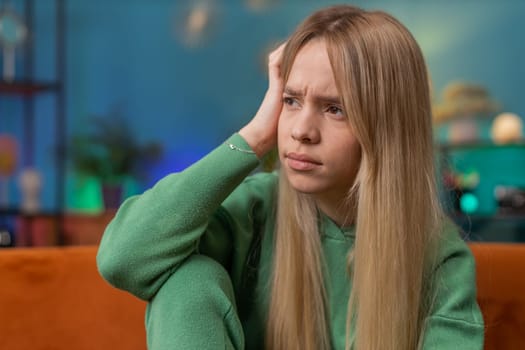 Sad lonely woman sits at home room looks pensive thinks over life concerns or unrequited love suffers from unfair situation. Alone teen girl problem, break up, depressed feeling bad annoyed burnout