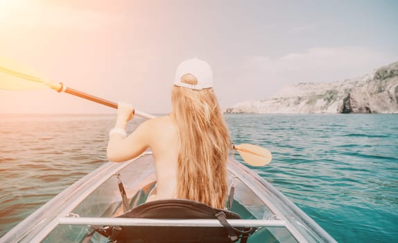 Woman in kayak back view. Happy young woman with long hair floating in transparent kayak on the crystal clear sea. Summer holiday vacation and cheerful female people having fun on the boat.